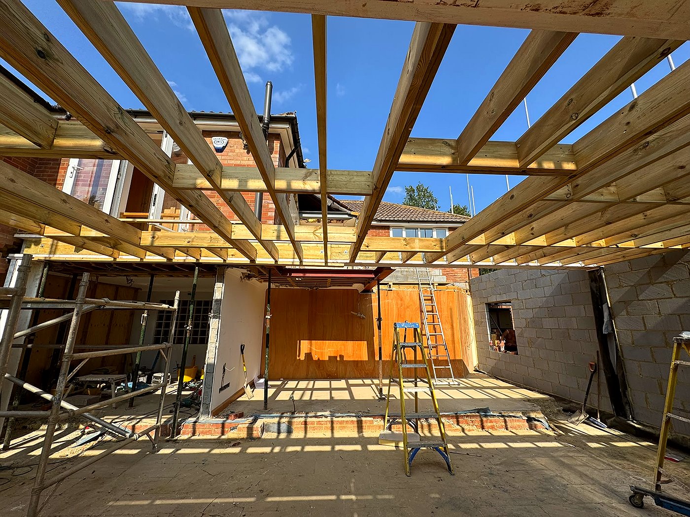 Rear extension under construction with new roof joists and a steel beam after removal of the entire ground-floor rear wall